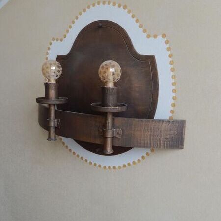 Nostalgische Wandlampe mit zwei Glühbirnen auf ovalem Holzelement